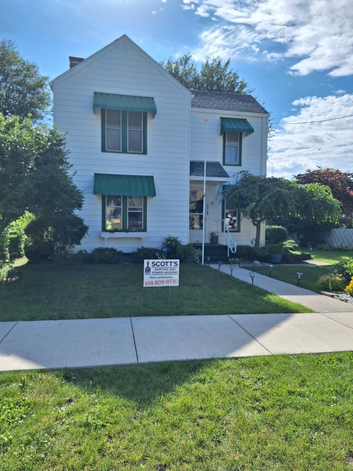 A white house with a for sale sign in front of it